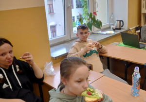 Młodzież spożywa zrobione przez siebie kanapki