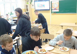 Uczniowie jedzą sałatkę