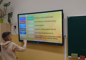 Uczeń rozwiązuje test na ekranie interaktywnym