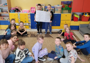 Uczniowie pozujący z plakatem dotyczącym wody.