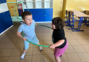 Dzieci kręcą się po okręgu hula hop